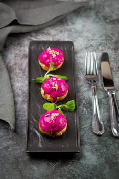 dessert of baked buns with raspberry topping and seed decorations