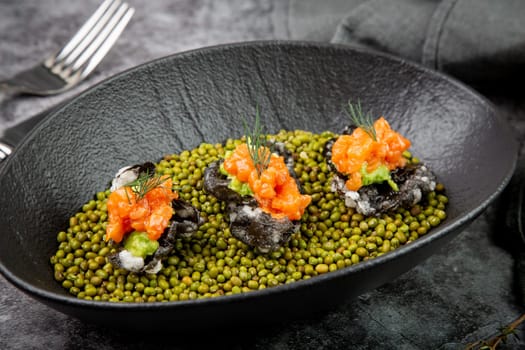 black caviar, red fish and wassabi on a plate with peas