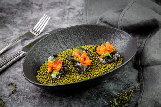 black caviar, red fish and wassabi on a plate with peas