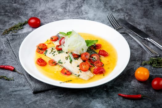 unpeeled fish with gravy, herbs, cherry tomatoes and onions