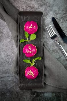 dessert of baked buns with raspberry topping and seed decorations