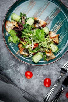 salad with arugula, lettuce, cucumber rolls, fish and sesame seeds