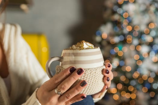 Morning coffee with whipped cream and marshmallows. Autumn composition. Hand with a cup. Composition with light cups and glass sugar bowl.