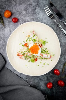 salad with mozzarella, caviar and green onions on a white plate