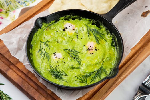 broccoli cream soup with herbs, cheese and tortillas in a frying pan