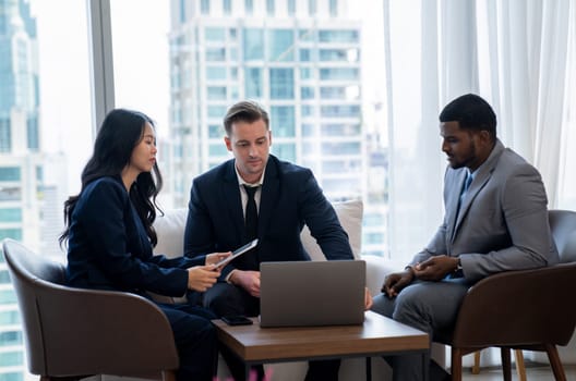 Young smart businesswoman showing data analysis to diverse investor by using tablet. Multicultural business group discussing and investing in start up project. Modern office. Meeting. Ornamented.