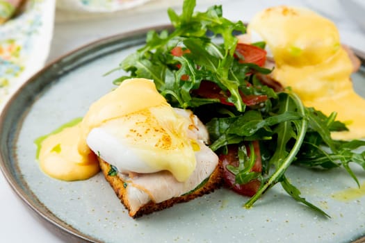 breakfast of arugula and tomato, toast with cheese and poached egg