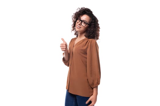 young curly brunette businesswoman dressed in a brown shirt with glasses.