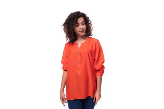 young stylish caucasian business woman with wavy hair dressed in an orange blouse on a background with copy space.