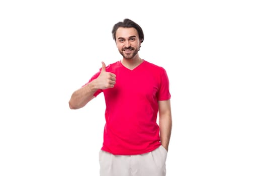 young pleasant slender brunette man with a cool hairstyle is dressed in a red t-shirt.