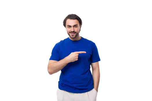 young authentic brunette man with a beard in a blue t-shirt on a white background with copy space.