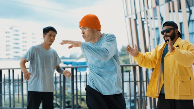 Hip hop team dance break dance while multicultural friend surrounded and clapping hands to cheer or encourage his friend to dance. Active and energetic street dance. Outdoor sport 2024. Endeavor.