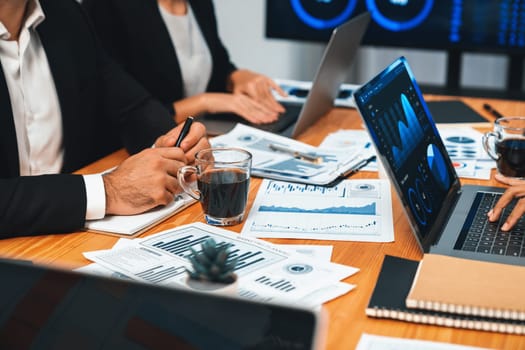 Diverse group of business analyst team analyzing financial data report paper on office table. Chart and graph dashboard by business intelligence analysis for strategic marketing planning Habiliment