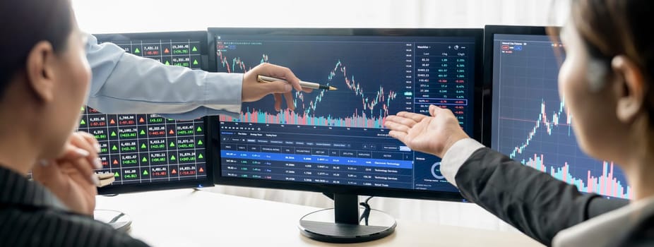 Expert successful businessman present stock market investment to smart beautiful investor during pointing the growth stock market graph. Cooperative trader discuss about investment. Burgeoning.