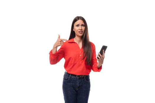young office worker woman with black hair dressed in a red blouse uses the phone.