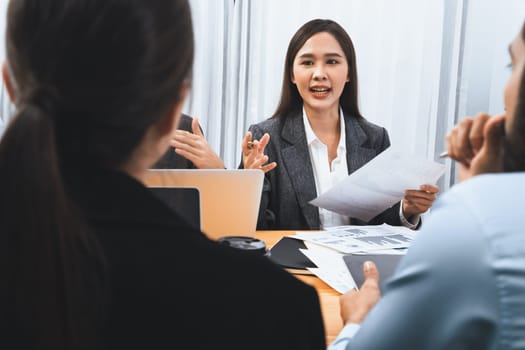 Multiracial analyst team use BI dashboard data to analyze financial report on meeting table. Group of diverse business people utilize data analysis by FIntech for business marketing decision. Concord