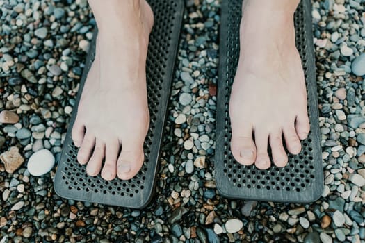 Sea Woman feet stepping on sadhu board during indian practice on the seashore. . Healthy lifestyle concept. tool for working out your inner state.