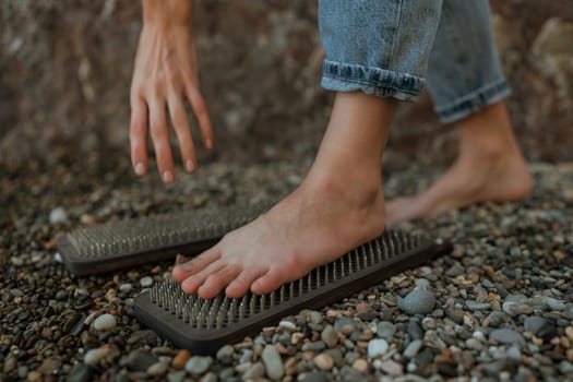 Sea Woman feet stepping on sadhu board during indian practice on the seashore. . Healthy lifestyle concept. tool for working out your inner state.