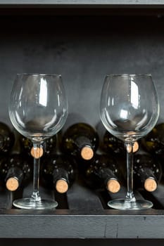 Red wine bottle and wine glasses in front of wooden wall. With copy space