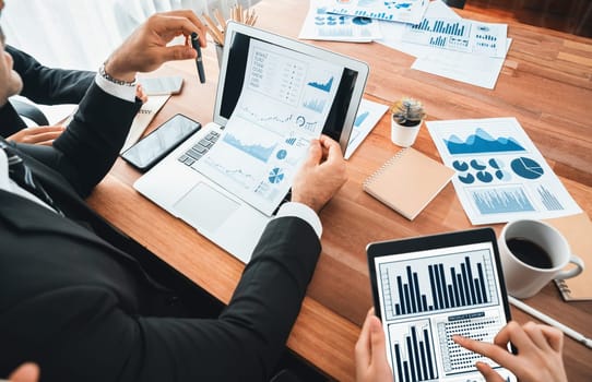 Diverse group of business analyst team analyzing financial data report paper on office table. Chart and graph dashboard by business intelligence analysis for strategic marketing planning Habiliment