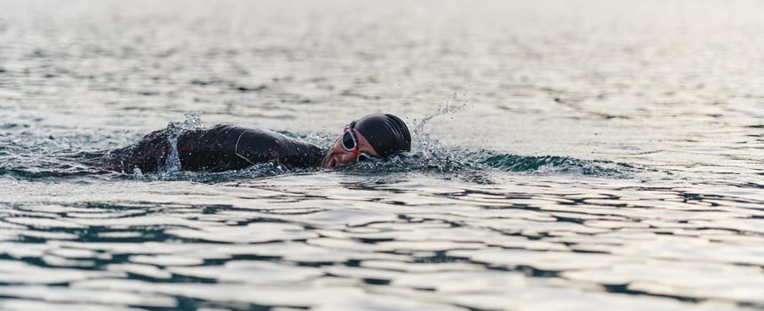 A professional triathlete trains with unwavering dedication for an upcoming competition at a lake, emanating a sense of athleticism and profound commitment to excellence