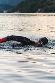 A professional triathlete trains with unwavering dedication for an upcoming competition at a lake, emanating a sense of athleticism and profound commitment to excellence