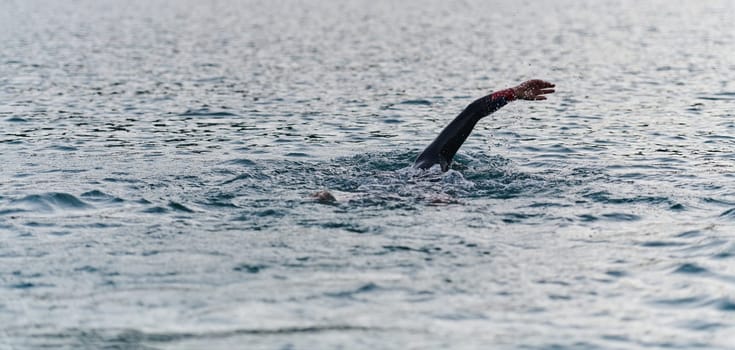 A professional triathlete trains with unwavering dedication for an upcoming competition at a lake, emanating a sense of athleticism and profound commitment to excellence