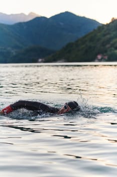 A professional triathlete trains with unwavering dedication for an upcoming competition at a lake, emanating a sense of athleticism and profound commitment to excellence