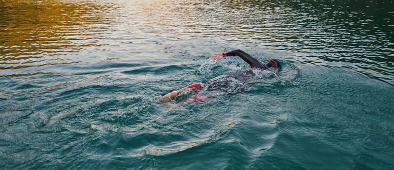 A professional triathlete trains with unwavering dedication for an upcoming competition at a lake, emanating a sense of athleticism and profound commitment to excellence