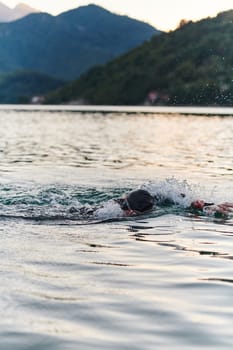 A professional triathlete trains with unwavering dedication for an upcoming competition at a lake, emanating a sense of athleticism and profound commitment to excellence