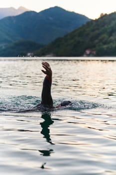 A professional triathlete trains with unwavering dedication for an upcoming competition at a lake, emanating a sense of athleticism and profound commitment to excellence