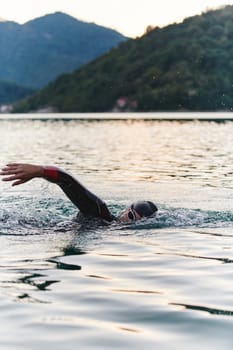 A professional triathlete trains with unwavering dedication for an upcoming competition at a lake, emanating a sense of athleticism and profound commitment to excellence