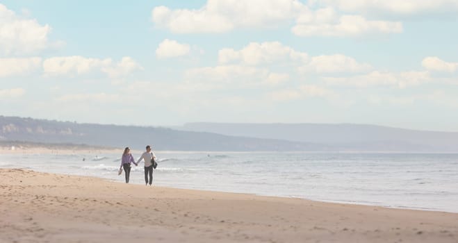 25 november 2023, Lisbon, Portugal - Love couple Walking on a Beach Near the Ocean - telephoto