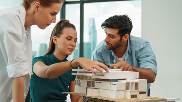Smart architect team discussion about house design while handsome male worker present idea by using laptop. Group of professional engineer sharing, brainstorming design. Business design. Tracery