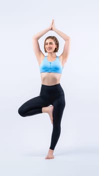 Full body length gaiety shot athletic and sporty woman doing healthy and meditative yoga exercise workout posture on isolated background. Healthy active and body care lifestyle