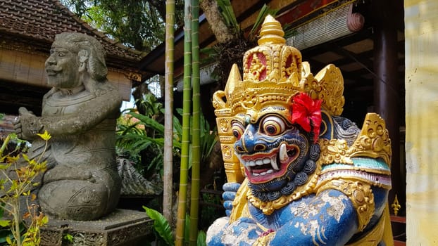 figure guarding the entrance to a Hindu temple, statue of sacred temple in Bali, balinese temple guardian, balinese gnome, Traditional Balinese statues or called Arca made of stone carvings in the form of gods, people or demons. Balinese sculpture in temple.