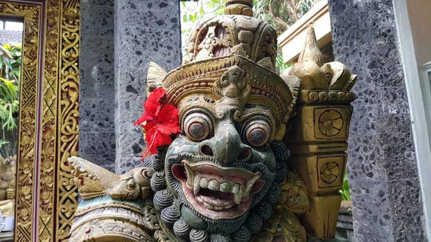 figure guarding the entrance to a Hindu temple, statue of sacred temple in Bali, balinese temple guardian, balinese gnome, Traditional Balinese statues or called Arca made of stone carvings in the form of gods, people or demons. Balinese sculpture in temple.