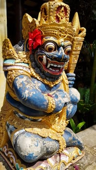figure guarding the entrance to a Hindu temple, statue of sacred temple in Bali, balinese temple guardian, balinese gnome, Traditional Balinese statues or called Arca made of stone carvings in the form of gods, people or demons. Balinese sculpture in temple.