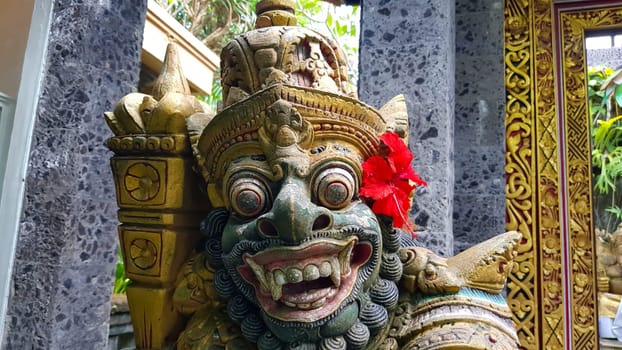 figure guarding the entrance to a Hindu temple, statue of sacred temple in Bali, balinese temple guardian, balinese gnome, Traditional Balinese statues or called Arca made of stone carvings in the form of gods, people or demons. Balinese sculpture in temple.