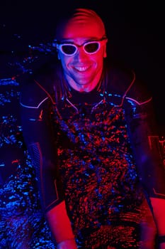 real triathlete swimmer having a break during hard training at lake on dark night neon gel color lights