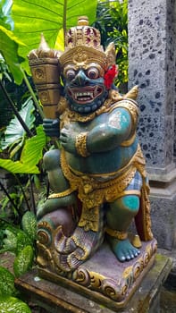 figure guarding the entrance to a Hindu temple, statue of sacred temple in Bali, balinese temple guardian, balinese gnome, Traditional Balinese statues or called Arca made of stone carvings in the form of gods, people or demons. Balinese sculpture in temple.