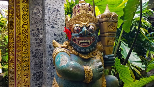 figure guarding the entrance to a Hindu temple, statue of sacred temple in Bali, balinese temple guardian, balinese gnome, Traditional Balinese statues or called Arca made of stone carvings in the form of gods, people or demons. Balinese sculpture in temple.
