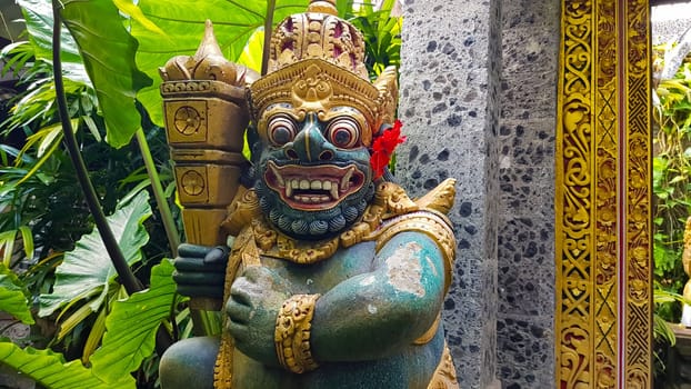figure guarding the entrance to a Hindu temple, statue of sacred temple in Bali, balinese temple guardian, balinese gnome, Traditional Balinese statues or called Arca made of stone carvings in the form of gods, people or demons. Balinese sculpture in temple.