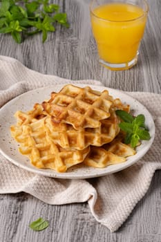 Waffles paired with a glass of freshly squeezed orange juice.