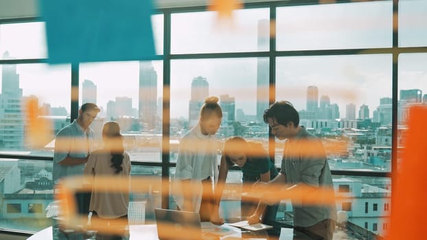 Group of diverse business people brainstorming about marketing plan. Multicultural business team working, talking, presenting about financial strategy with idea written on glass wall. Tracery