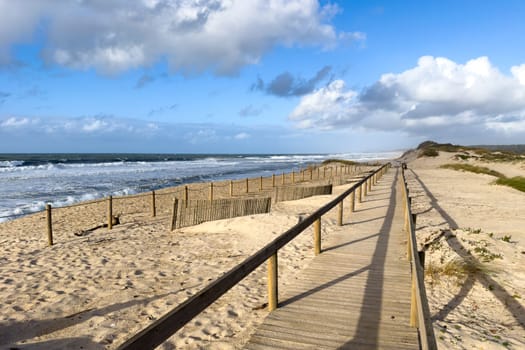 Wooden pathway leading to the beach on the throught the sand dunes at Furadouro - Ovar, Portugal.