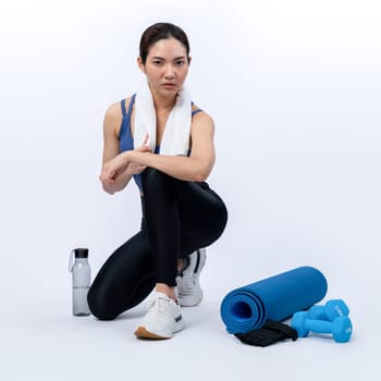 Athletic and sporty asian woman resting after intensive cardio workout training. Healthy exercising and fit body care lifestyle pursuit in studio shot isolated background. Vigorous