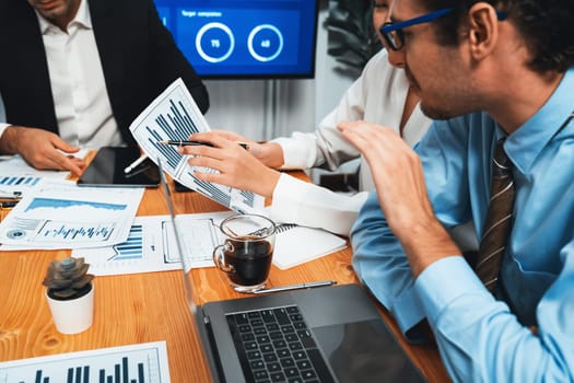 Diverse group of business analyst team analyzing financial data report. Finance data analysis chart and graph dashboard show on TV screen in meeting room for strategic marketing planning. Habiliment