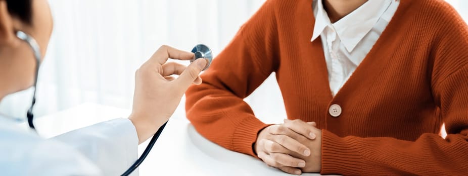 Patient attend doctor's appointment at clinic or hospital office. Doctor examining and diagnosis symptoms while checking the patient's pulse with stethoscope. Panorama Rigid