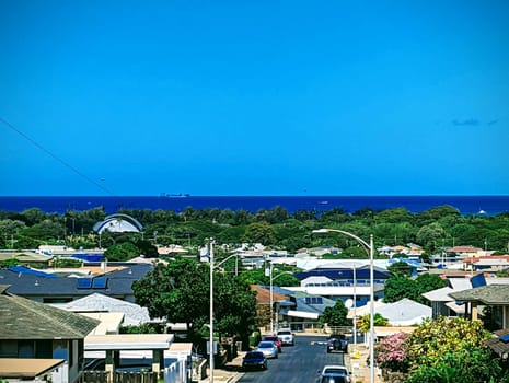 Honolulu - August 11, 2023: A photo of an aerial view of Kapahulu and Waikiki in the distance, with blue skies and ocean. The photo shows the contrast between the urban and the natural landscape, as well as the diversity and vibrancy of the city.